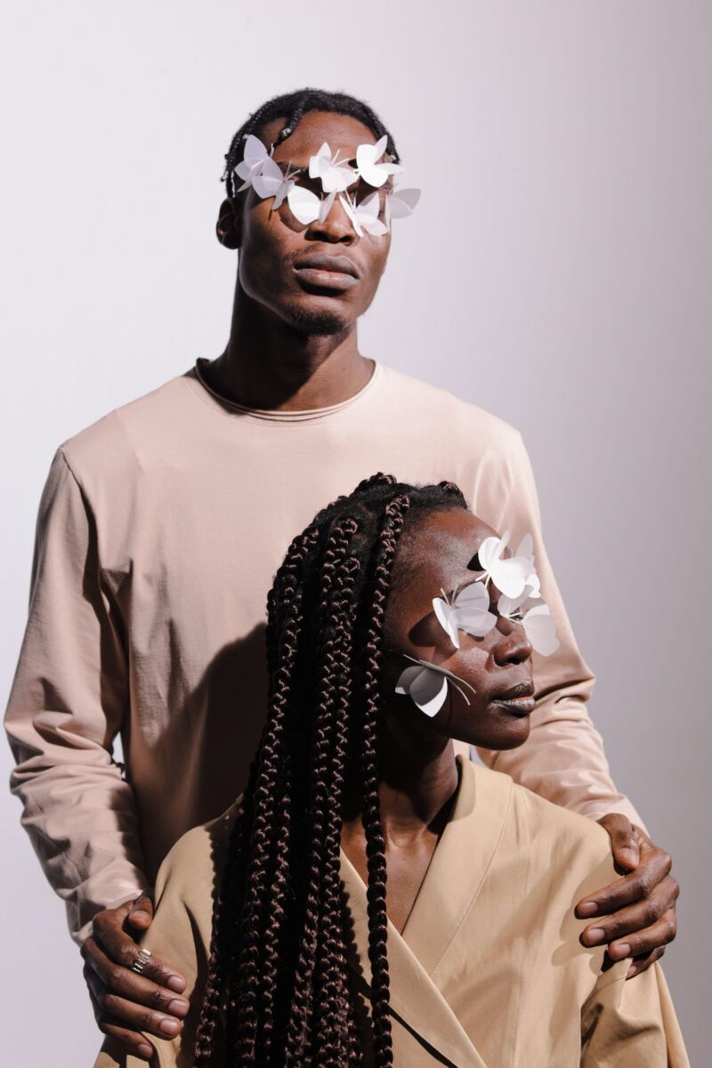 Two people with a visual impairment. There's white butterflies covering their eyes.