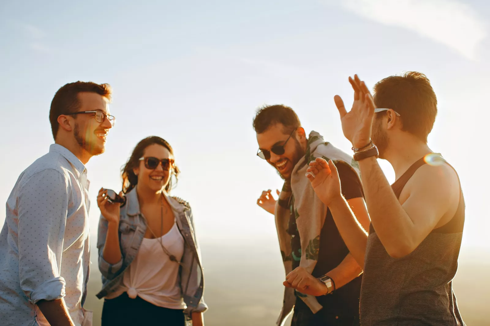 Vier millenials met telefoon in hand dansen