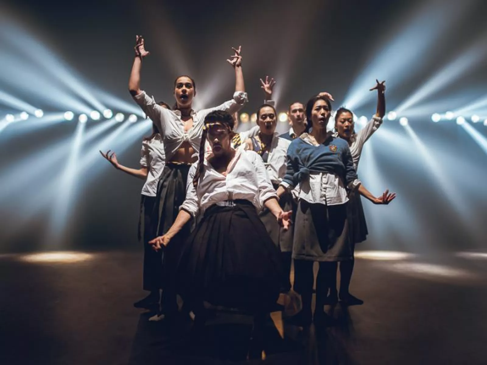 Dansers op een podium, met lichten die het publiek in schijnen