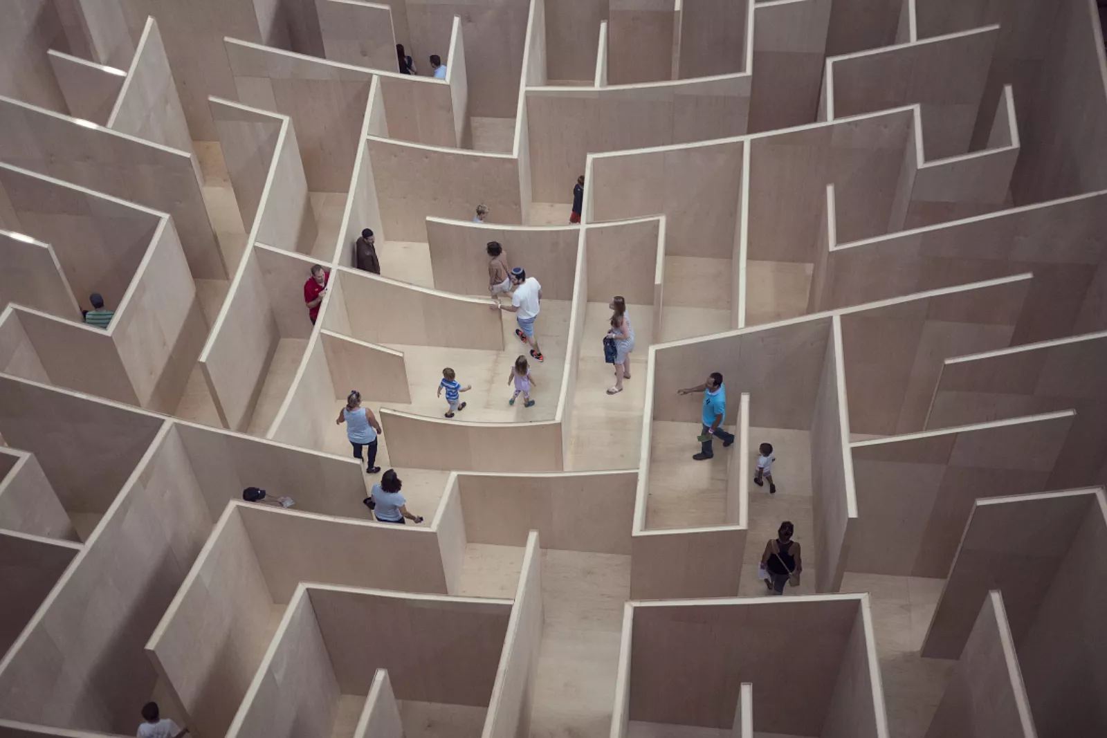 De afbeelding toont vanuit vogelperspectief hoe mensen door een doolhof bewegen.