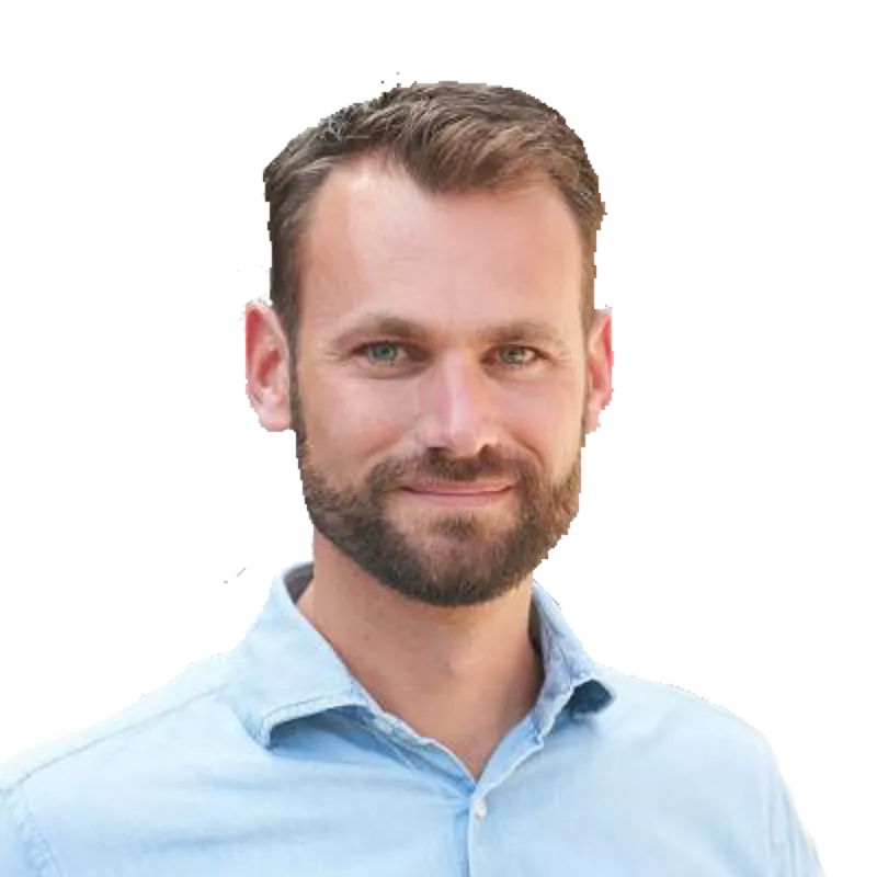 Portret van een man met kort haar en een baard in een lichtblauw overhemd.